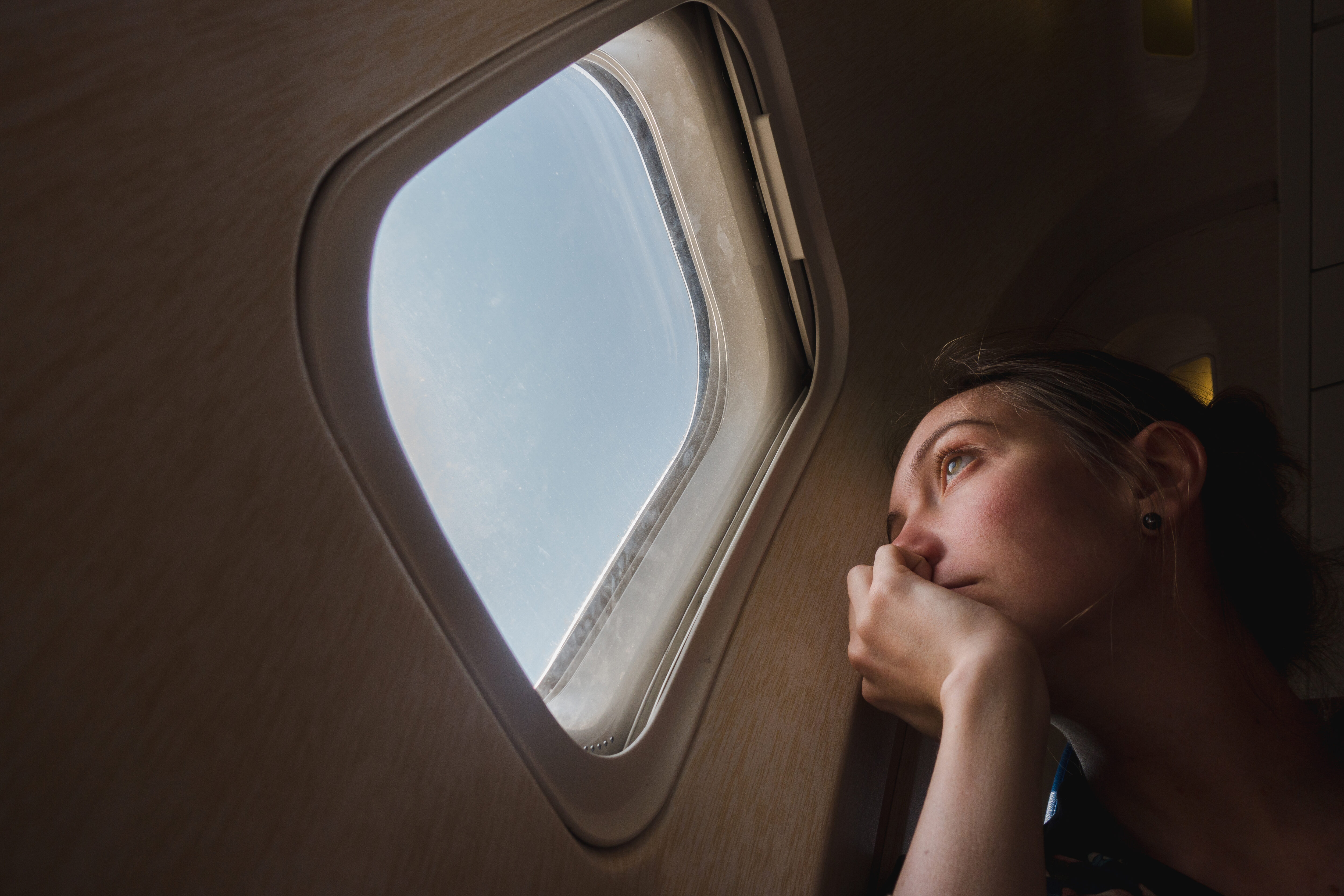 woman sitting in an airplane staring out of the window