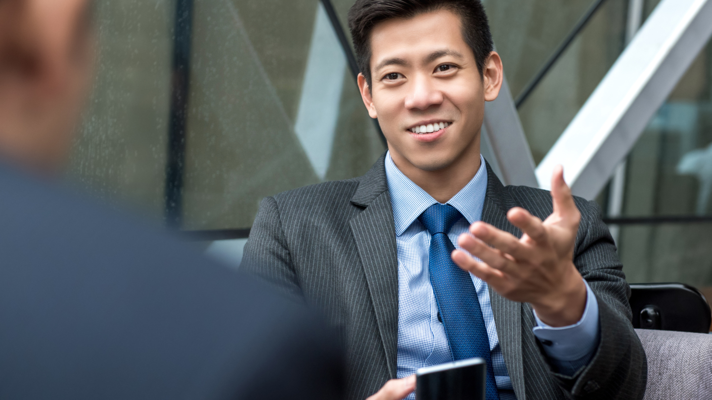 an Asian businessman talking to another person